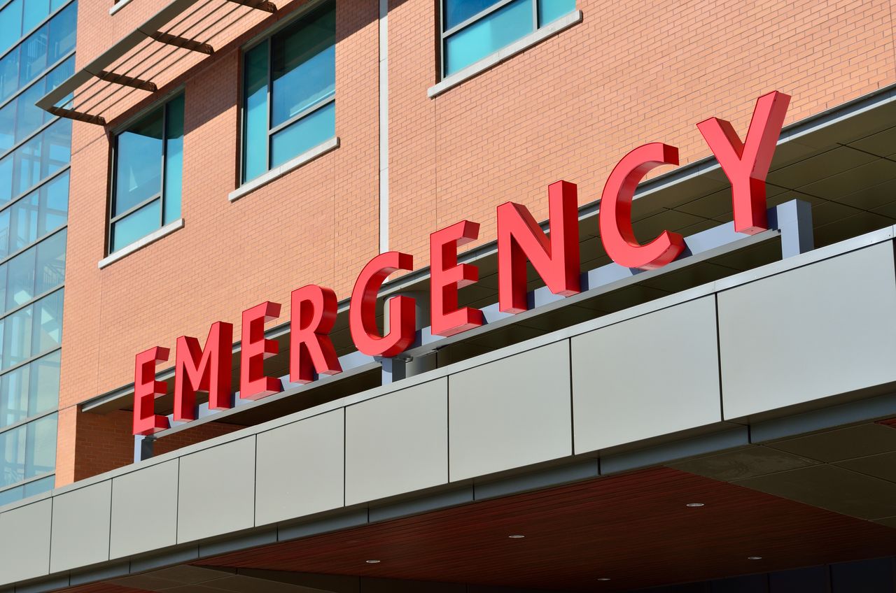 Red emergency department sign on the exterior of a hospital building