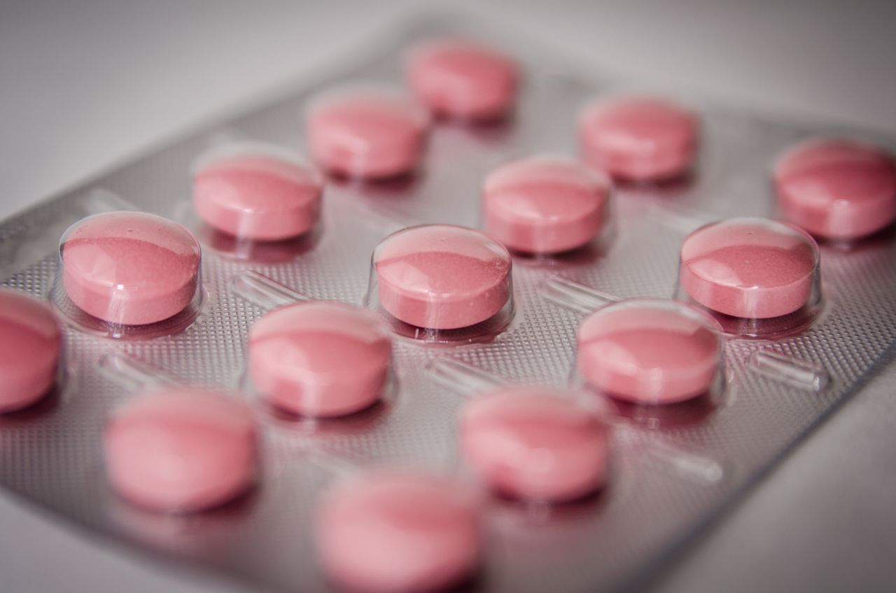 Close-up of pink round antimalarial tablets in a clear plastic blister pack