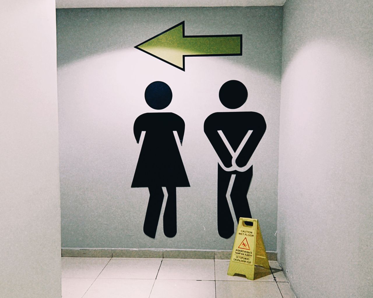 Public restroom sign with a directional arrow, illustrating traveller's diarrhoea guidance